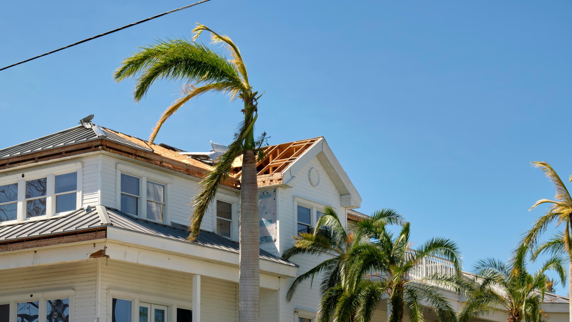 Damaged house roof with missing shingles after hurricane Ian in Florida. Consequences of natural disaster Damaged house roof with missing shingles after hurricane Ian in Florida. Consequences of natural disaster.
